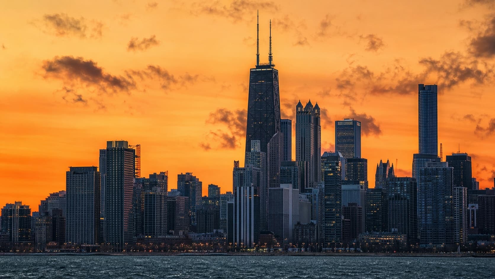 Chicago skyline at sunset with the John Hancock Center against an orange sky